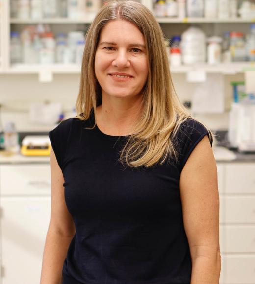 The picture shows Gitta Coaker Standing in a Lab